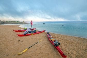 Kayaks varados en la playa en una etapa de la ruta